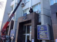 С админзданий в Севастополе госсимволы Украины демонтируют с помощью лома и строительного крана