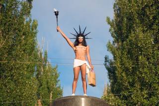 В Киеве активистка FEMEN взобралась на постамент Ленину и разбрасывала конфеты Roshen